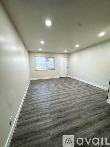 A room with wooden flooring and a window.