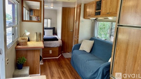 A blue couch is in the living room of a trailer.