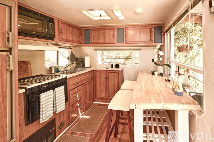 A kitchen with wooden cabinets and a stove top oven.