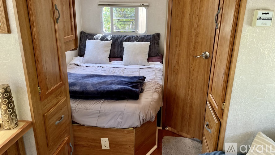 A bedroom with a bed, nightstand, and a window.