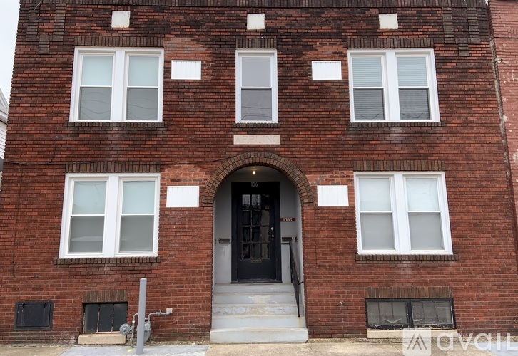 A red brick building with a black door and windows.