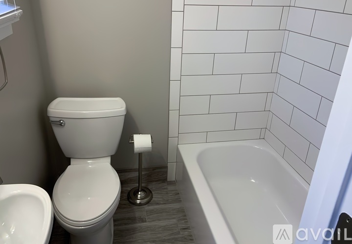 A white toilet sits next to a white sink in a bathroom.