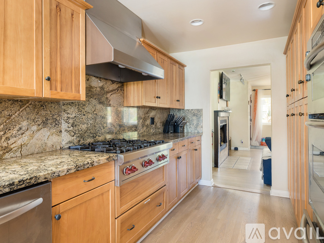 A kitchen with wooden cabinets and a marble countertop.
