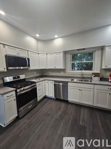 A kitchen with white cabinets and a window.