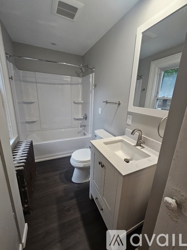 A bathroom with a toilet, sink, and shower.