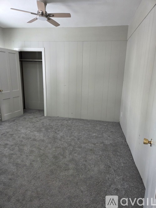 A room with a ceiling fan and a door.