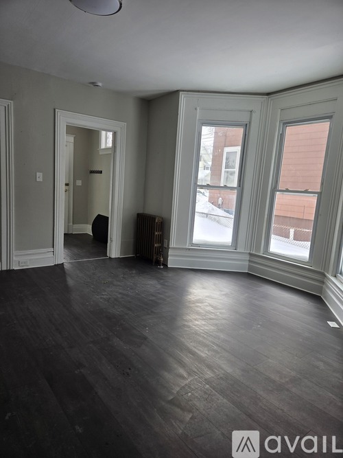 A room with wooden floors and a large window.