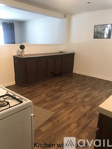 A kitchen with a white stove and wooden floors.