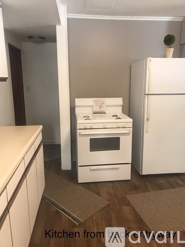 A kitchen with a white oven and refrigerator.