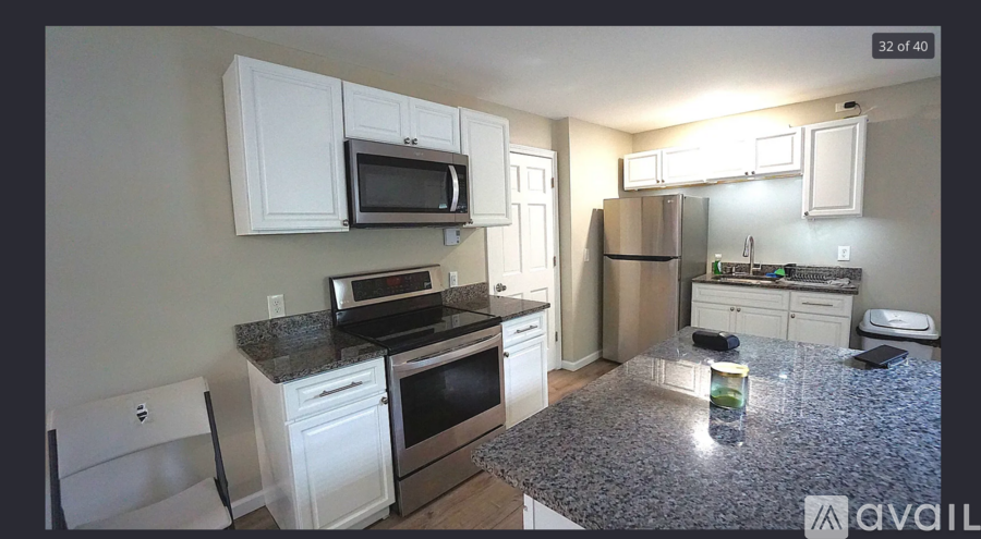 A kitchen with granite countertops and white cabinets.