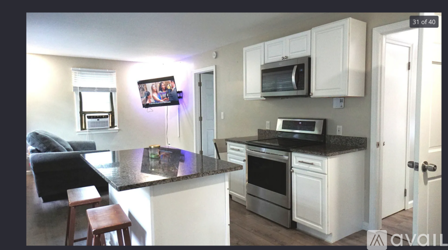 A kitchen with white cabinets and a black countertop.