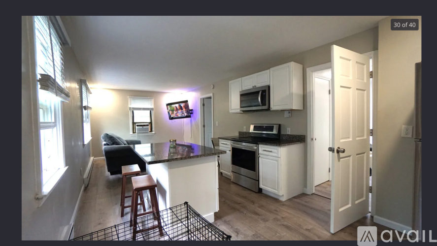A kitchen with white cabinets and a black countertop.