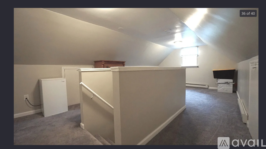 A room with a white refrigerator and a cabinet against the wall.