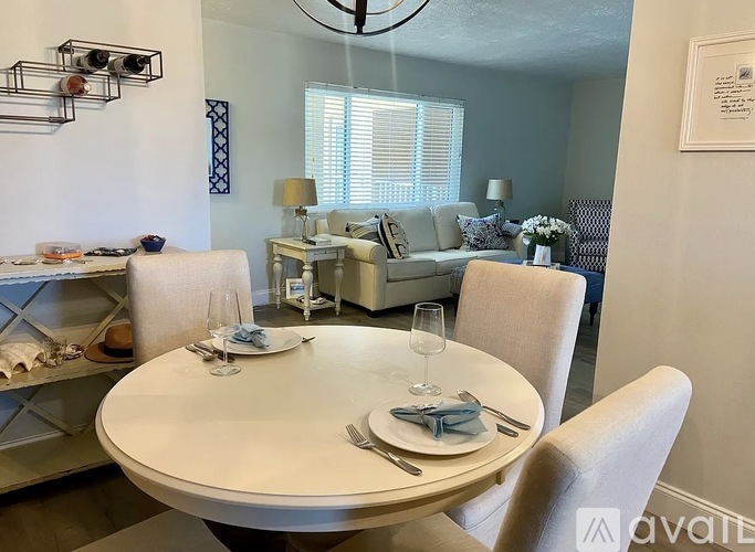 A dining room with a white table set for two.