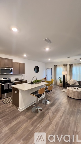 A modern kitchen with a white island and wooden flooring.