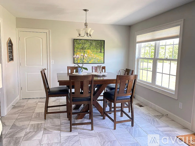 A dining room with a table and chairs.