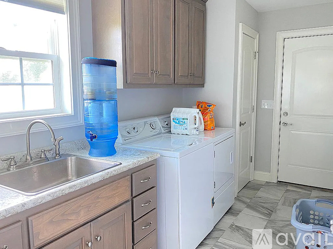 A kitchen with a white dishwasher and wooden cabinets.
