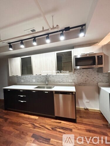 A kitchen with a wooden floor and a white counter top.