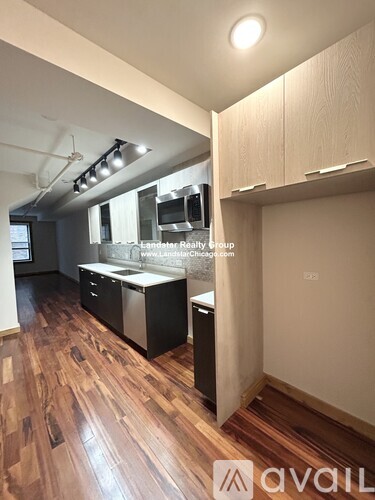 A kitchen with wooden floors and a stainless steel dishwasher.