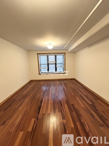 A room with wooden flooring and a window.