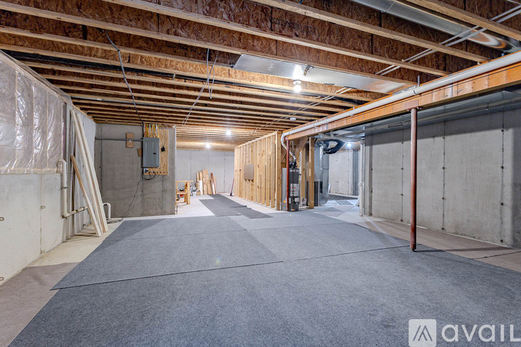 A spacious unfinished basement with a concrete floor and exposed ceiling.