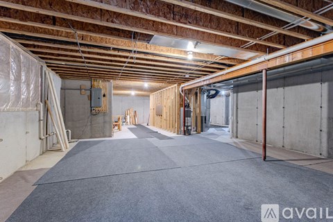 A spacious unfinished basement with a concrete floor and exposed ceiling.