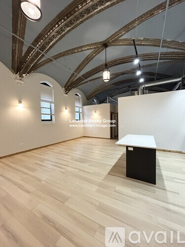 A room with wooden floors and a white wall with a black object on it.