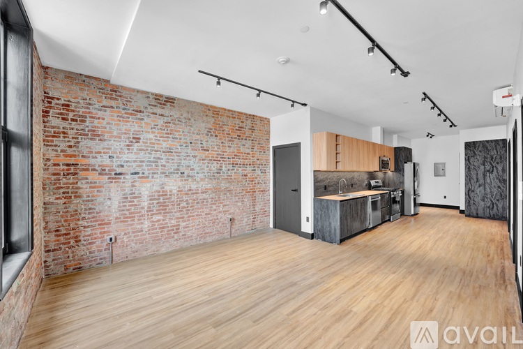 A room with a brick wall and wooden flooring.