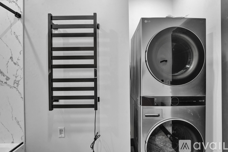 A black and white photo of a washing machine in a laundry room.