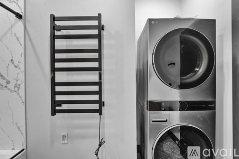 A black and white photo of a washing machine in a laundry room.