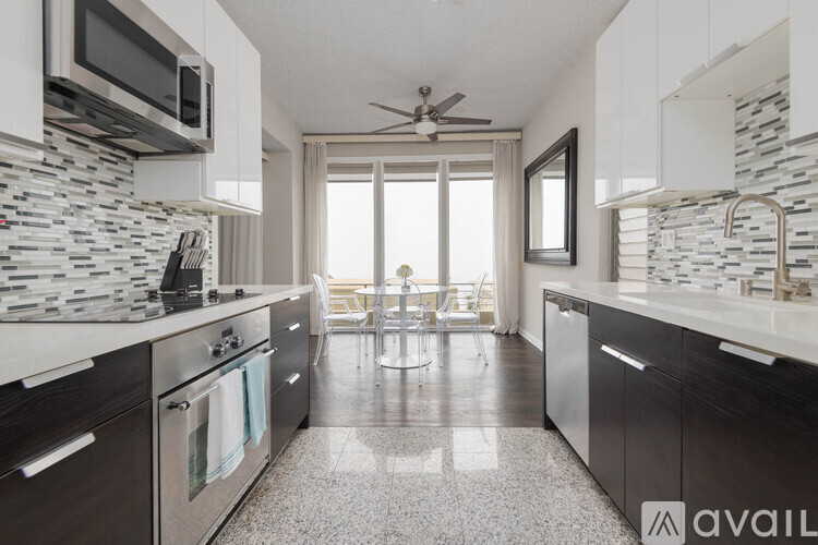 A modern kitchen with dark wood cabinets and a marble backsplash.