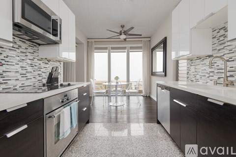 A modern kitchen with dark wood cabinets and a marble backsplash.