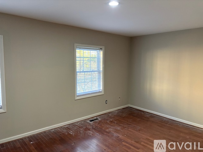 A room with a window and wooden flooring.