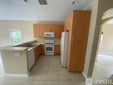 A kitchen with wooden cabinets and white appliances.