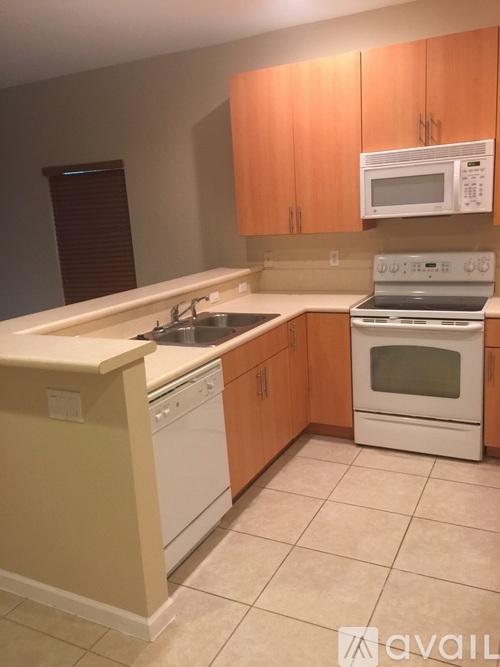 A kitchen with a white stove top oven and a white dishwasher.
