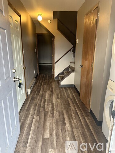A hallway with a washing machine in the corner.