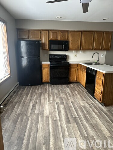 A kitchen with a black refrigerator and black stove.