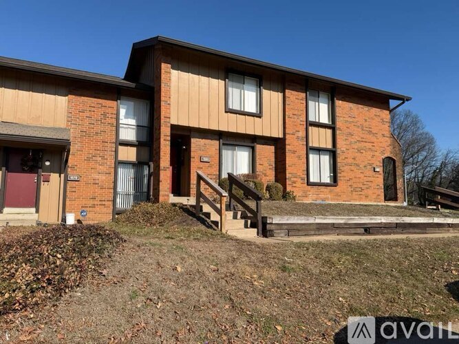 A two-story brick house with a balcony on the second floor.