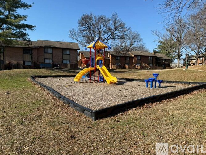 A playground with a yellow slide and blue bucket.