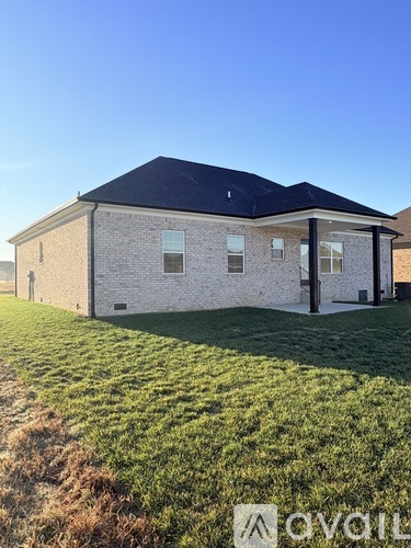A house with a black roof and a grassy area in front.