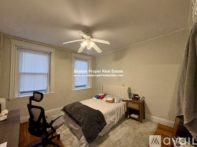 A bedroom with a bed, chair, and window.