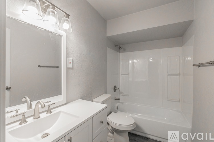 A white bathroom with a sink, toilet, and bathtub.