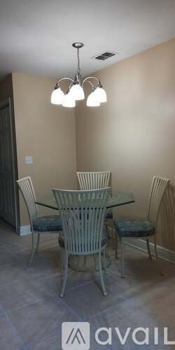A dining room with a glass table and chairs.