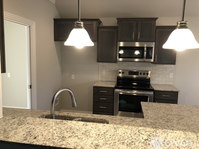 A kitchen with granite countertops and stainless steel appliances.