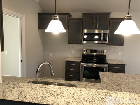 A kitchen with granite countertops and stainless steel appliances.