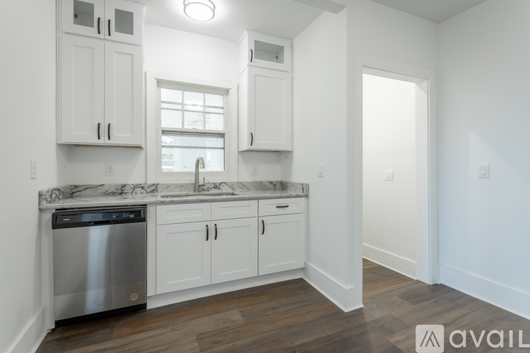 A kitchen with white cabinets and a stainless steel dishwasher.