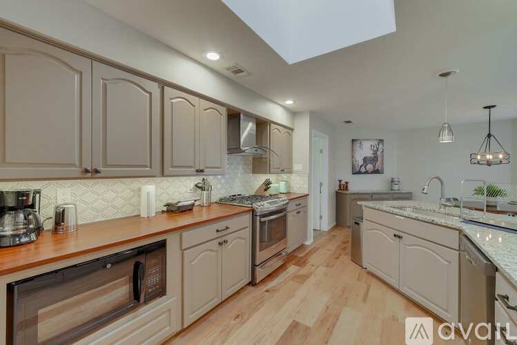 A kitchen with wooden cabinets and a skylight.