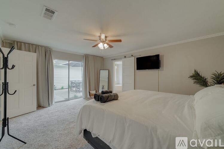 A bedroom with a large bed and a ceiling fan.