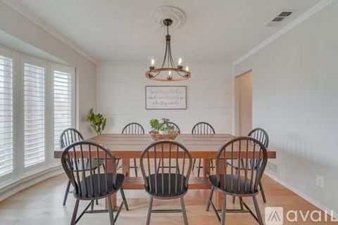 A dining room with a wooden table and chairs.