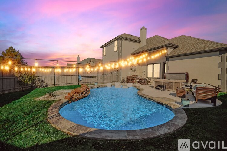 A house with a pool and lights around it.
